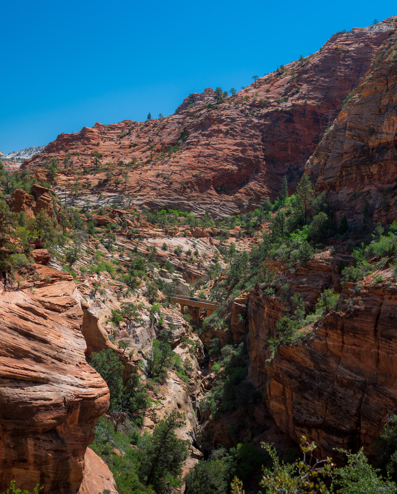 A small bridge spanning a steep red-rock canyon
