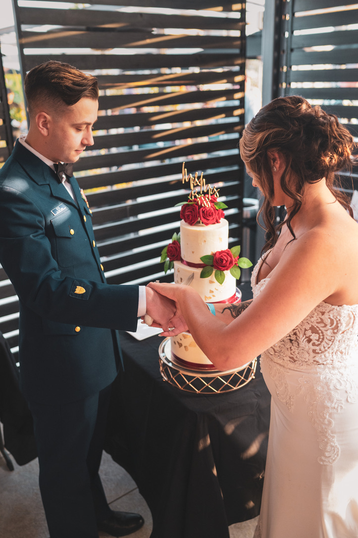 A newlywed couple cutting their wedding cake together